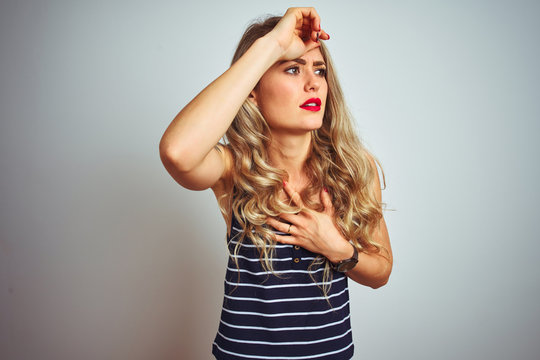 Young beautiful woman wearing stripes t-shirt standing over white isolated background Touching forehead for illness and fever, flu and cold, virus sick