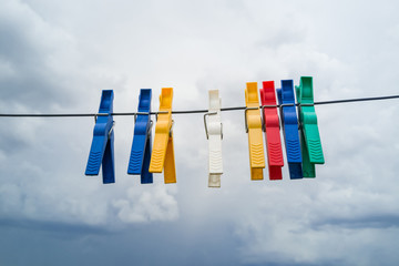 Colored clothes pegs attached to clothesline to dry 