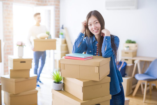 Beautiful young asian couple looking happy, young woman smiling excited moving to a new home