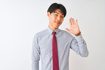 Chinese businessman wearing elegant tie standing over isolated white background Waiving saying hello happy and smiling, friendly welcome gesture