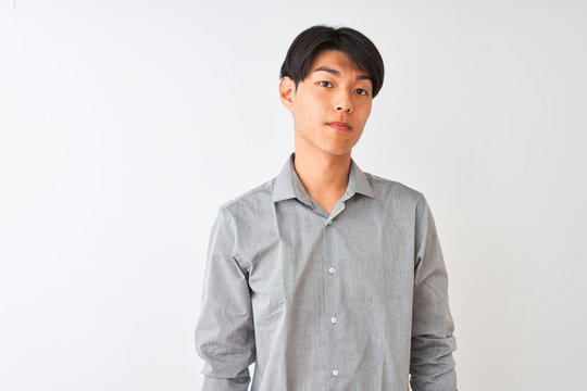 Chinese Businessman Wearing Elegant Shirt Standing Over Isolated White Background With Serious Expression On Face. Simple And Natural Looking At The Camera.