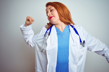 Young redhead doctor woman using stethoscope over white isolated background stretching back, tired...