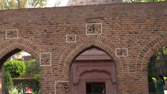 a close pan of bullet marks on a wall at jallianwala bagh in amritsar, india