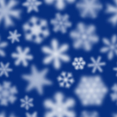 Christmas seamless pattern of white defocused snowflakes on blue background