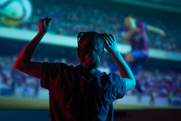 The girl is watching football, soccer in 3D, with glasses on the big screen. with entertainment and relaxation. action, rest in the cinema. Cheerleader, fan