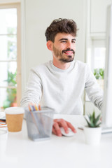 Young handsome man working using computer, smiling concentrated on internet