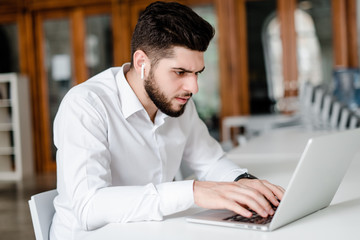 man at workplace with laptop in the office