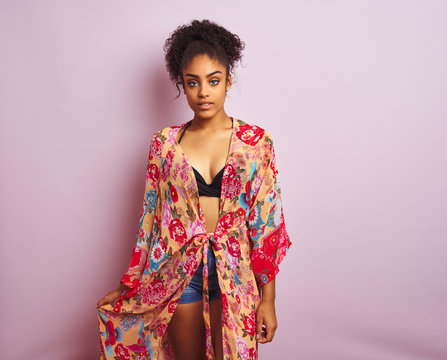 Young beautiful african american woman on vacation standing wearing bikini and colorful caftan