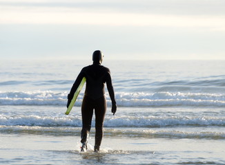 Surfboarder enters water near Westport Lighthouse State park