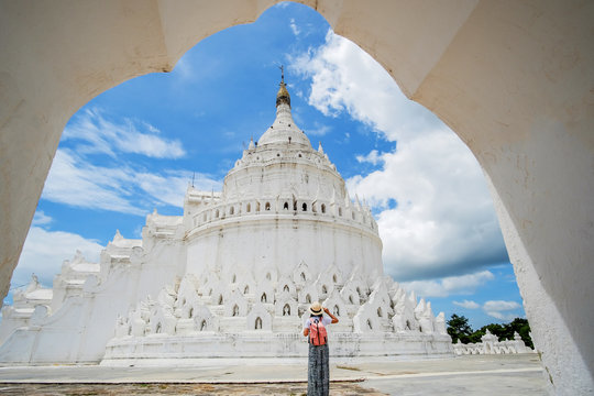 young woman traveling with bag visit Hsinbyume Pagoda (Mya Thein Dan) or called white Taj Mahal of Irrawaddy river, located in Mingun, Sagaing region near Mandalay, Myanmar. landmark and popular