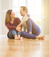 Fototapeta premium Beautiful romantic couple sitting together on the floor at home