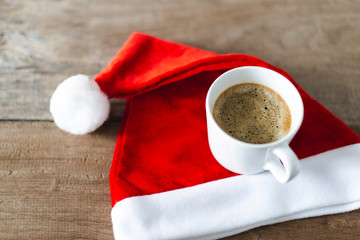 Obraz na płótnie Canvas top view a cup of coffee with Santa cross hat 