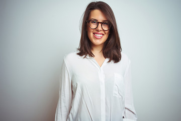 Obraz premium Young beautiful business woman wearing glasses over isolated background with a happy and cool smile on face. Lucky person.