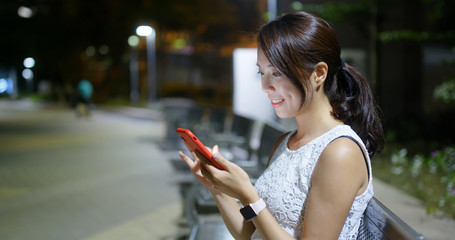 Woman look at mobile phone at park