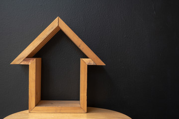wooden toy house with black wall background