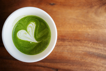 The latte art geen r\tea on the wood table 