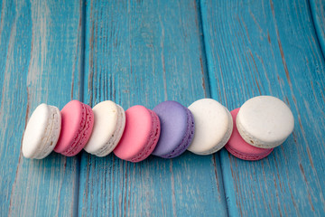 Cake macaron or macaroon on turquoise background from above, colorful almond cookies, pastel colors