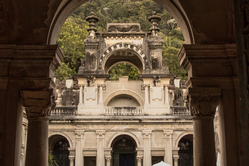 Rio de Janeiro, Brazil - August 17, 2019: Weathered colonial architecture of the public Parque Lage, built in the 1920s, reflects the jungle forest of the surrounding Tijuca National Park.