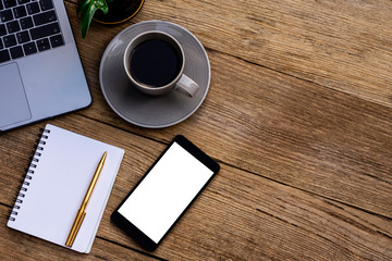 Mock up image of white digital tablet with blank screen,diary notebook, pen, cup of coffee and flowers on wooden table background. clipping path and copy space for your text, Top view