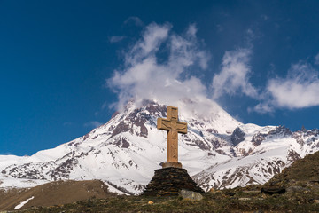 Holy cross on the background of Mount Kazbek near the Trinity Church