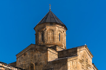 Fototapeta na wymiar Trinity Church in Gergeti on a background of blue sky