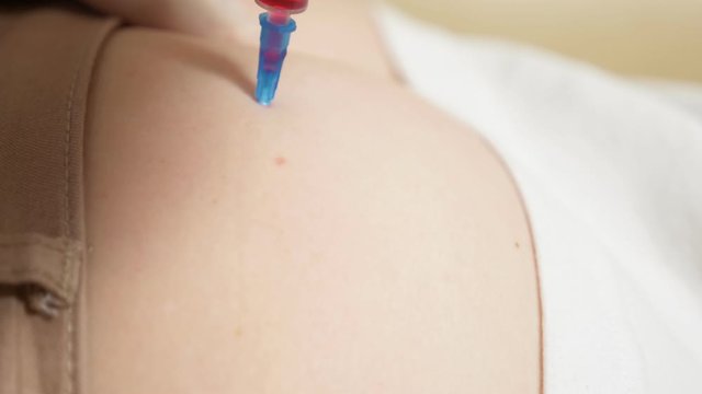 close-up, the doctor puts an injection into the buttock of the patient.