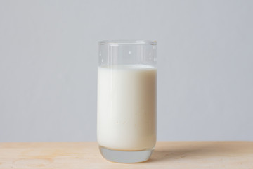 Close up milk in glass on table over withe background. 