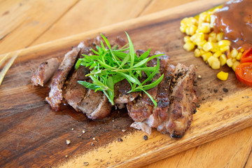 Pork steak with a sauce and rosemary on a wooden background