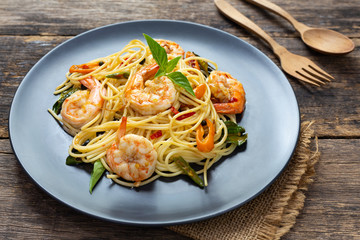 Spaghetti on black plate on wooden background. top view