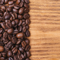 Coffee bean. The background of roasted coffee beans is brown on wooden boards. layout. Flat lay.