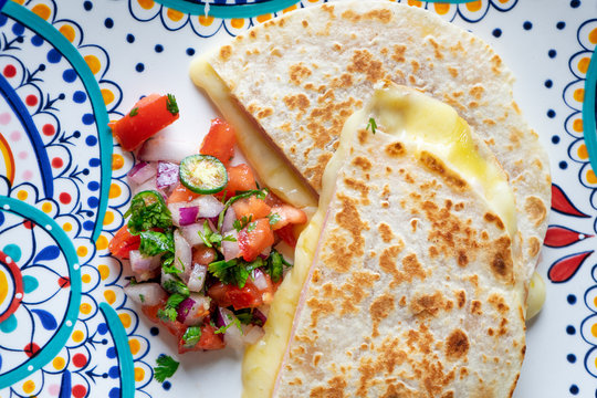 Mexican quesadillas with sliced ham also called "sincronizadas" on colorful  background