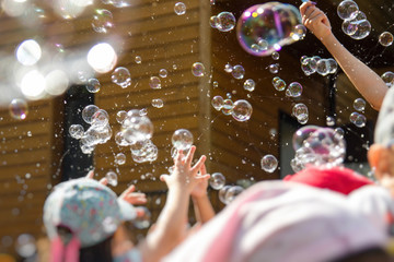 Children playing with soap bubbles in kindergarten outdoor.