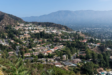 Fototapeta na wymiar Upscale hillside homes near Los Angeles in Glendale California with morning mist and San Gabriel mountains in background.