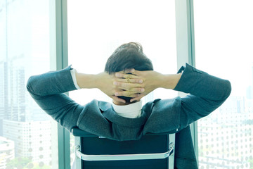 Man, he relaxes. In his office and look at the windows, admire the beauty of the country in modern city.