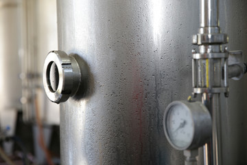 Close-up shiny tank or barrel at a beer and wine factory. Industry Brewing and winemaking. Equipment for the winery and brewing industrial 