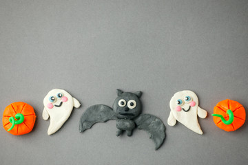 Funny toy pumpkins, ghost, bat from plasticine molded children. Scary Halloween background with open space for text. Banner. Creative DIY idea for kids