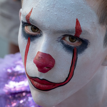 Halloween Makeup Like Pennywise. Street Performer Clown With A White Face. The Look Of A Man In The Guise Of IT On A Costume Cosplay Show. Close-up.