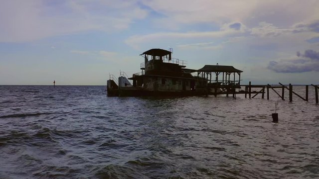 Semi sunken push boat docked in a river on a cloudy day