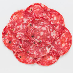 Salami sliced on a white background.