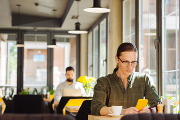 Serious handsome man looking at the smartphone screen