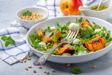 Fresh arugula salad with nectarines and pesto.