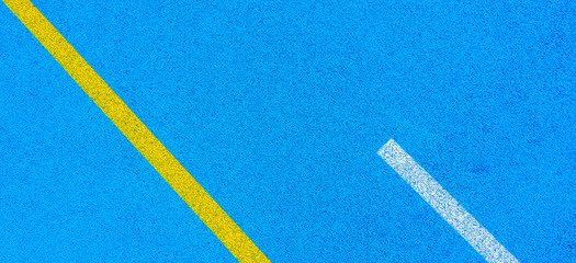 Fototapeta na wymiar Colorful sports court banner background. Top view blue field rubber ground with white and yellow lines outdoors