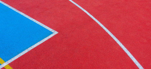 Colorful sports court background. Top view to red and blue field rubber ground with white and...