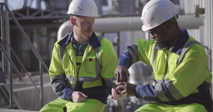 Industrial workers on a break. Multiracial informal communication at work