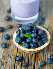 blueberry smoothie in a glass on wooden surface