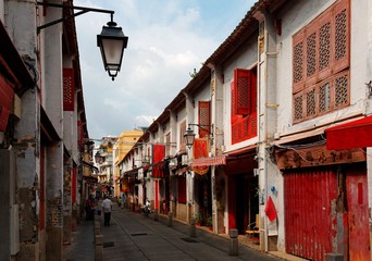 Fototapeta na wymiar Perspective view of the Street of Happiness (Rua da Felicidade) flanked by traditional Chinese houses with conspicuous red doors and windows in Macau, China This is a bygone Red Light district