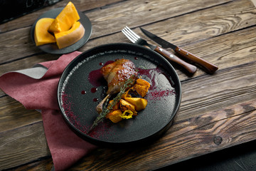Roasted duck leg with confit pumpkin, closeup. Horizontal top view, top shot. Copy space, wooden...