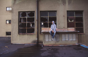 Portrait of a handsome caucasian man sitting in an old abandoned building