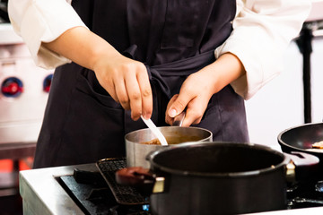 Obraz na płótnie Canvas Chef cooking, Chef preparing food in the kitchen, closeup.