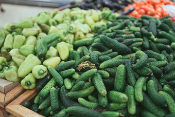 Cucumbersand and green pepper in wooden box. Fresh bell pepper green and cucumbers in wooden box with straw